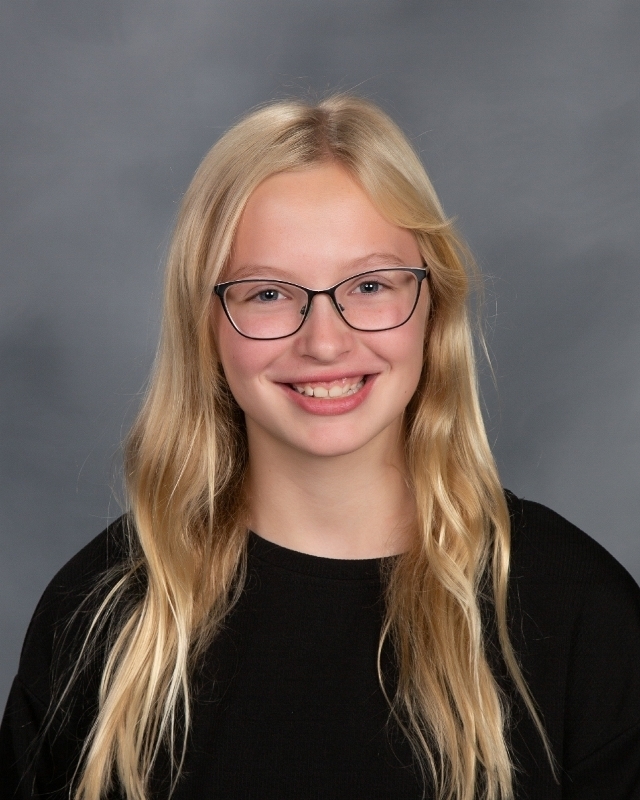 blonde female student with glasses wearing a black shirt